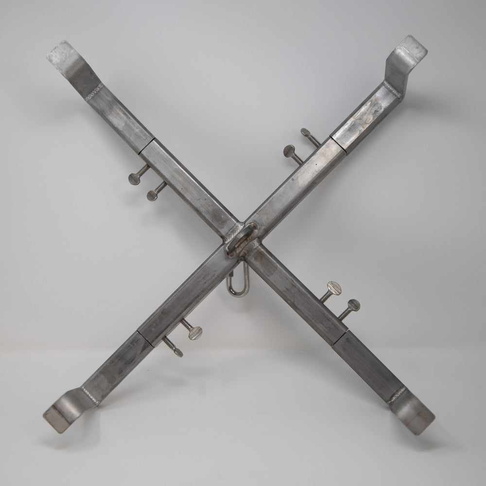 A metal cross featuring four metal hooks attached to its structure, showcasing a simple yet functional design.