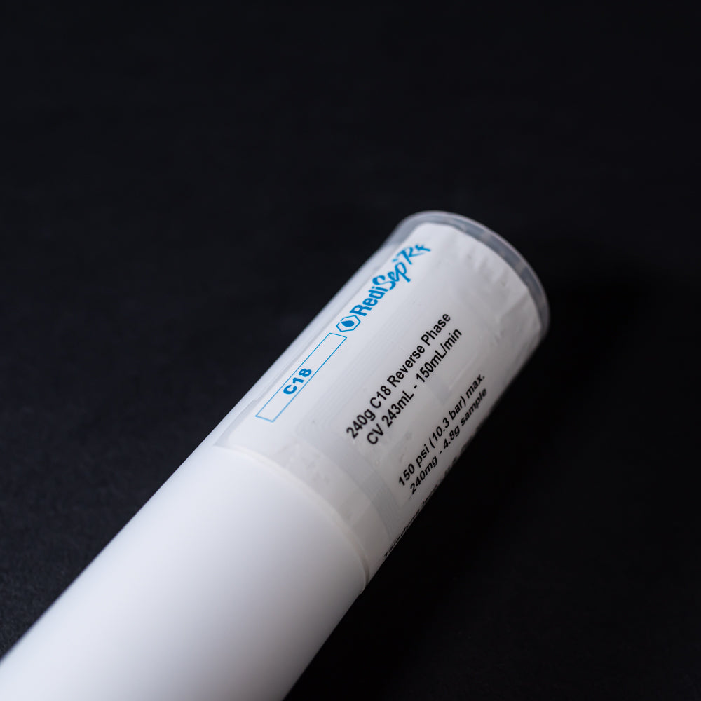 A small white tube with red caps displayed on a black background, creating a striking visual contrast between the two elements.