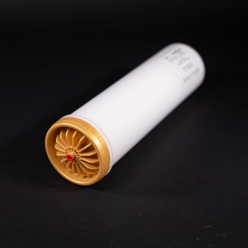 A small white tube with gold and red caps displayed on a black background, creating a striking visual contrast between the two elements.