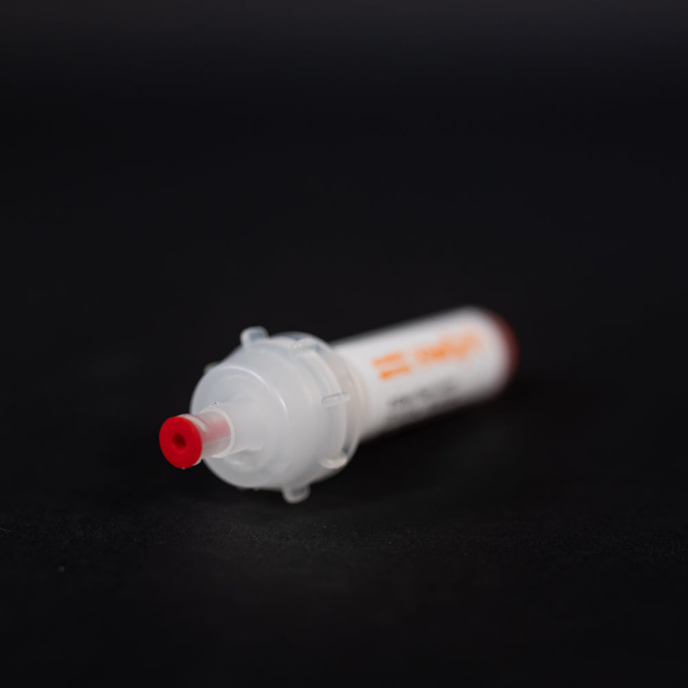 A small white tube with red caps displayed on a black background, creating a striking visual contrast between the two elements.