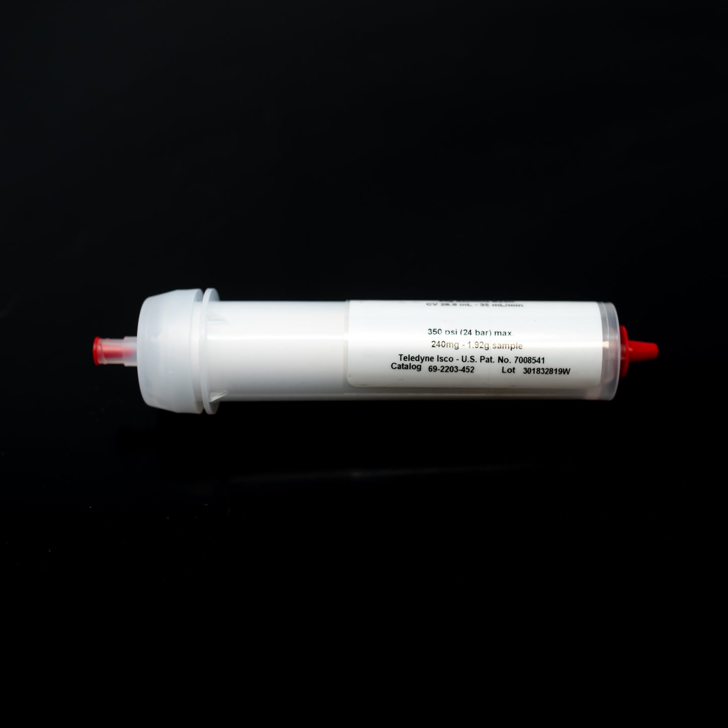 A white tube with vibrant red caps resting on a dark black surface, emphasizing a clean and contemporary design.
