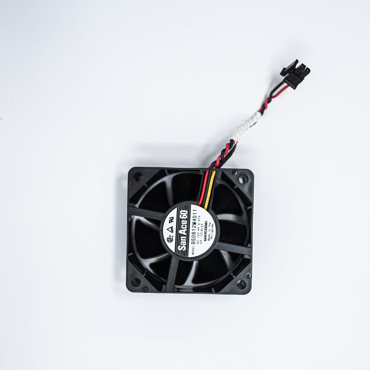 A black fan with visible wires set against a clean white background, highlighting its design and functionality.
