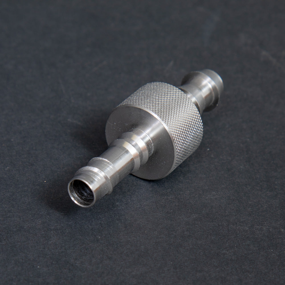 A small metallic threaded connector displayed on a dark black surface, emphasizing its detailed threading and craftsmanship.