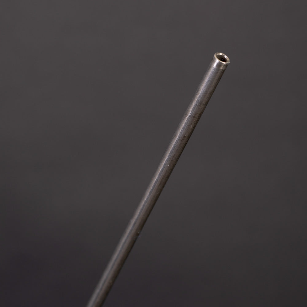A slender metal rod with a small hole positioned at one end, displayed against a neutral background.