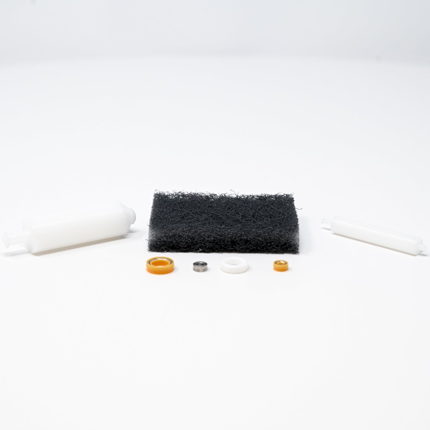 A collection of parts including seals, washers, bushings, o-rings, removal tools and scour pad.