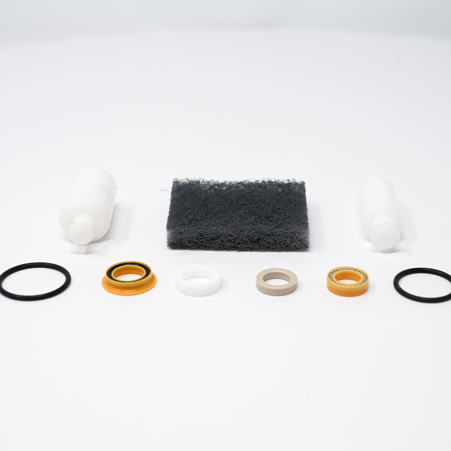 A collection of parts including seals, washers, bushings, o-rings, removal tools and scour pad.