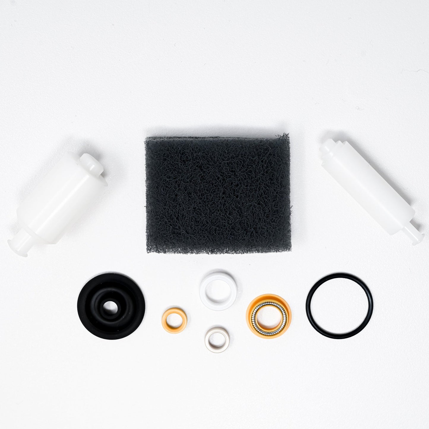 A collection of parts including seals, washers, bushings, o-rings, removal tools and scour pad.