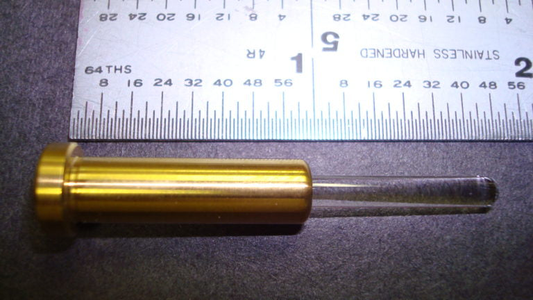 A metal cylinder positioned beside a ruler, illustrating a measurement context in a clear and concise manner.