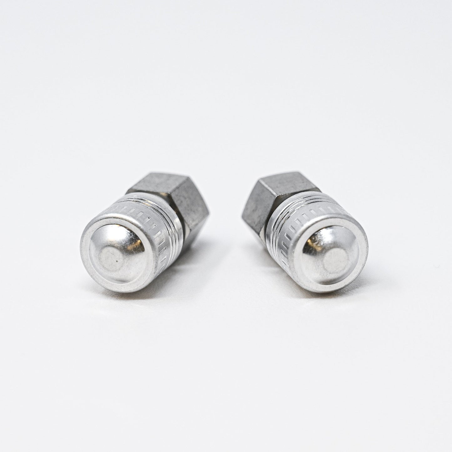 Two stainless steel fittings displayed against a clean white background, showcasing their metallic finish and design.