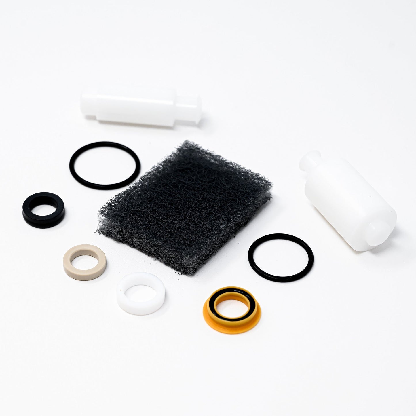 A collection of parts including seals, washers, bushings, o-rings, removal tools and scour pad.