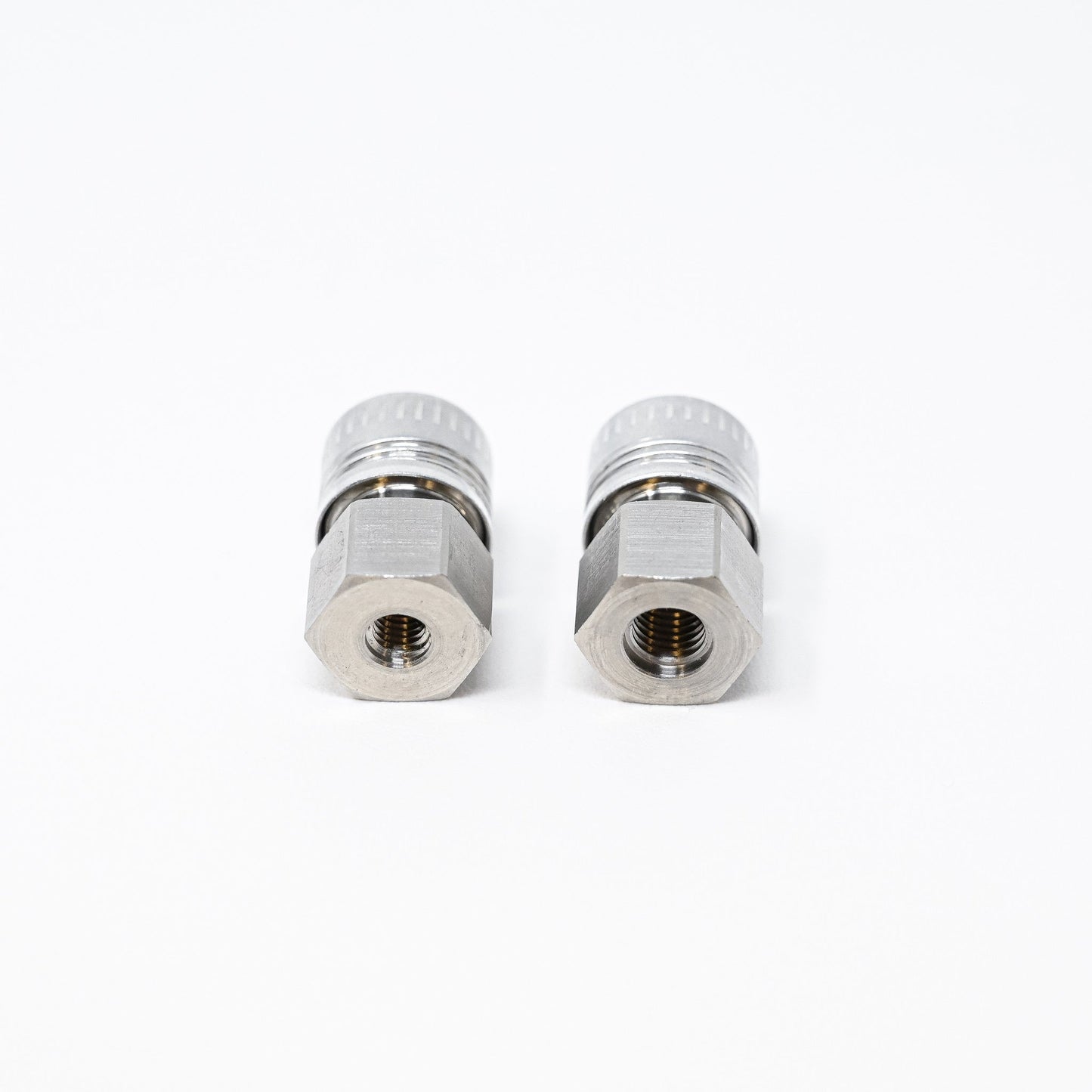 Two stainless steel threaded fittings displayed against a clean white background, showcasing their metallic finish and design.