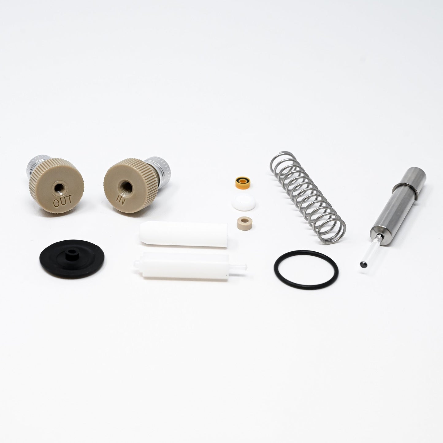 A collection of components for a pump, including various fittings and mechanical parts arranged neatly.