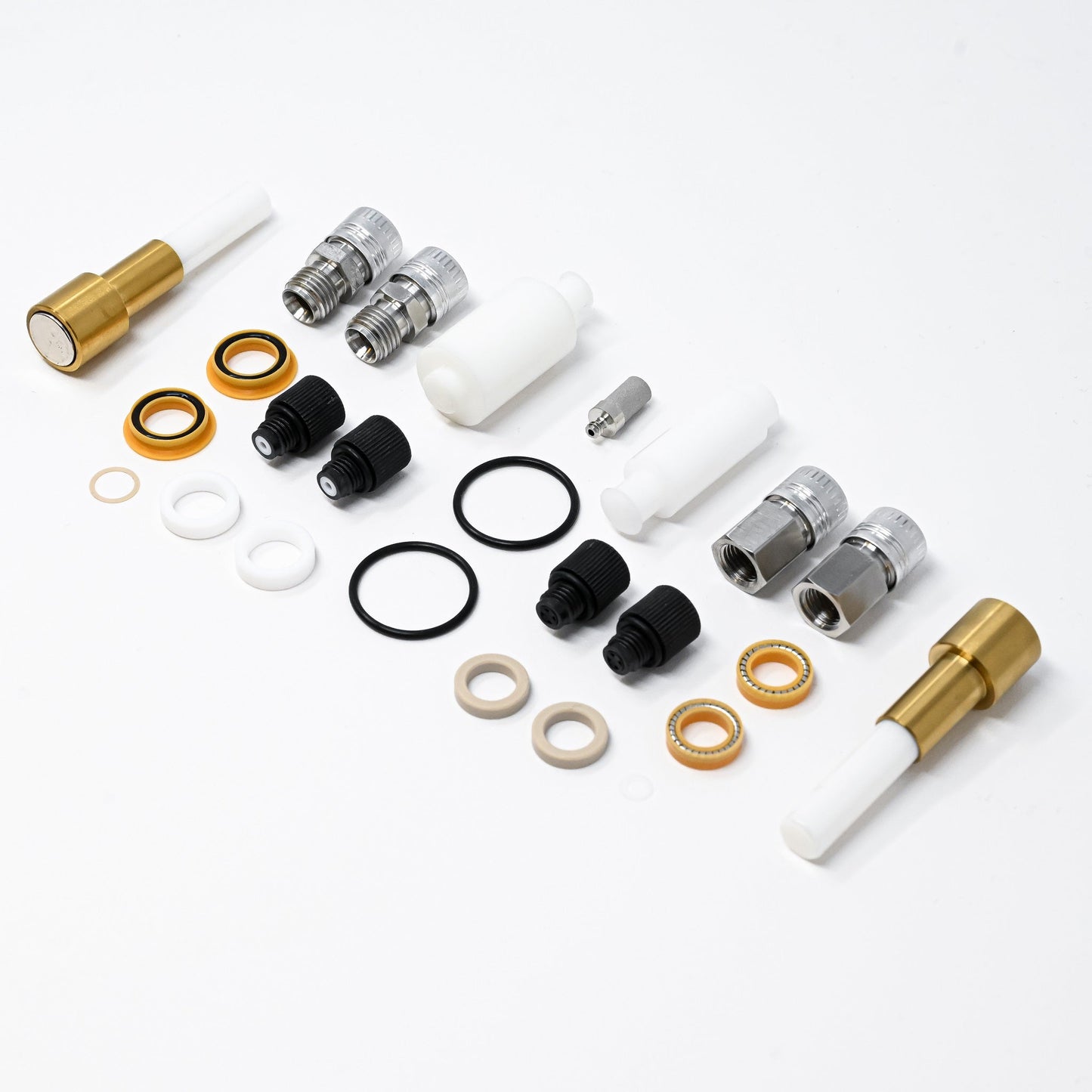 A collection of components for a pump, including various fittings and mechanical parts arranged neatly.