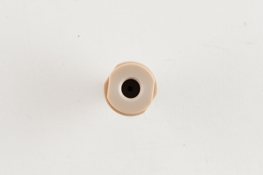 A tan object featuring a prominent hole at its center, creating a striking contrast in colors.
