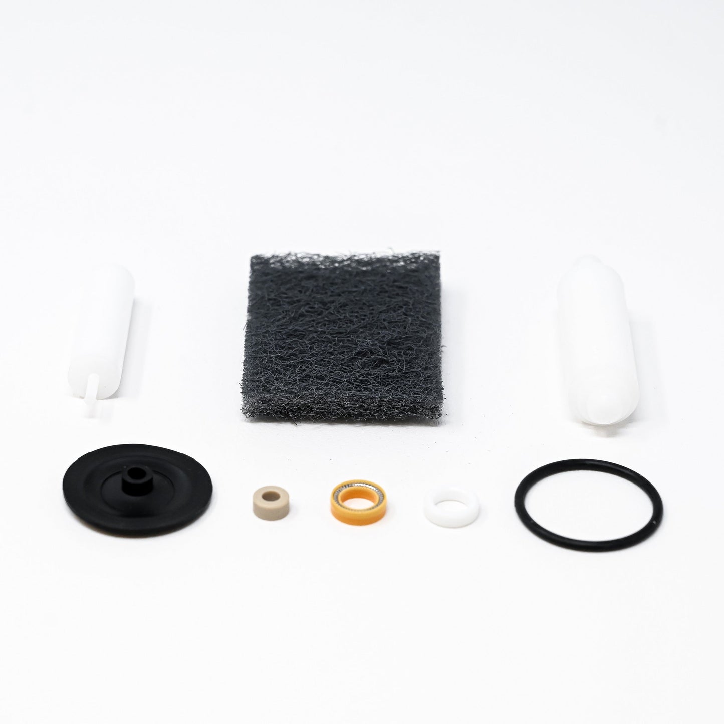 A collection of parts including seals, washers, bushings, o-rings, removal tools and scour pad.