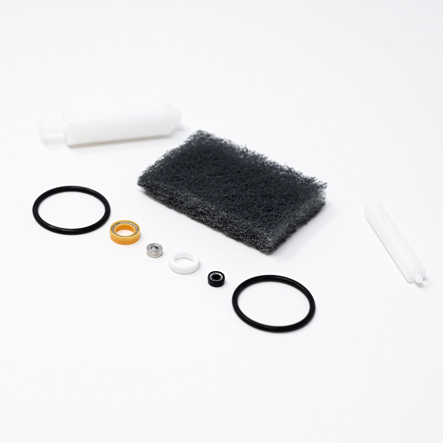 A collection of parts including seals, washers, bushings, o-rings, removal tools and scour pad.