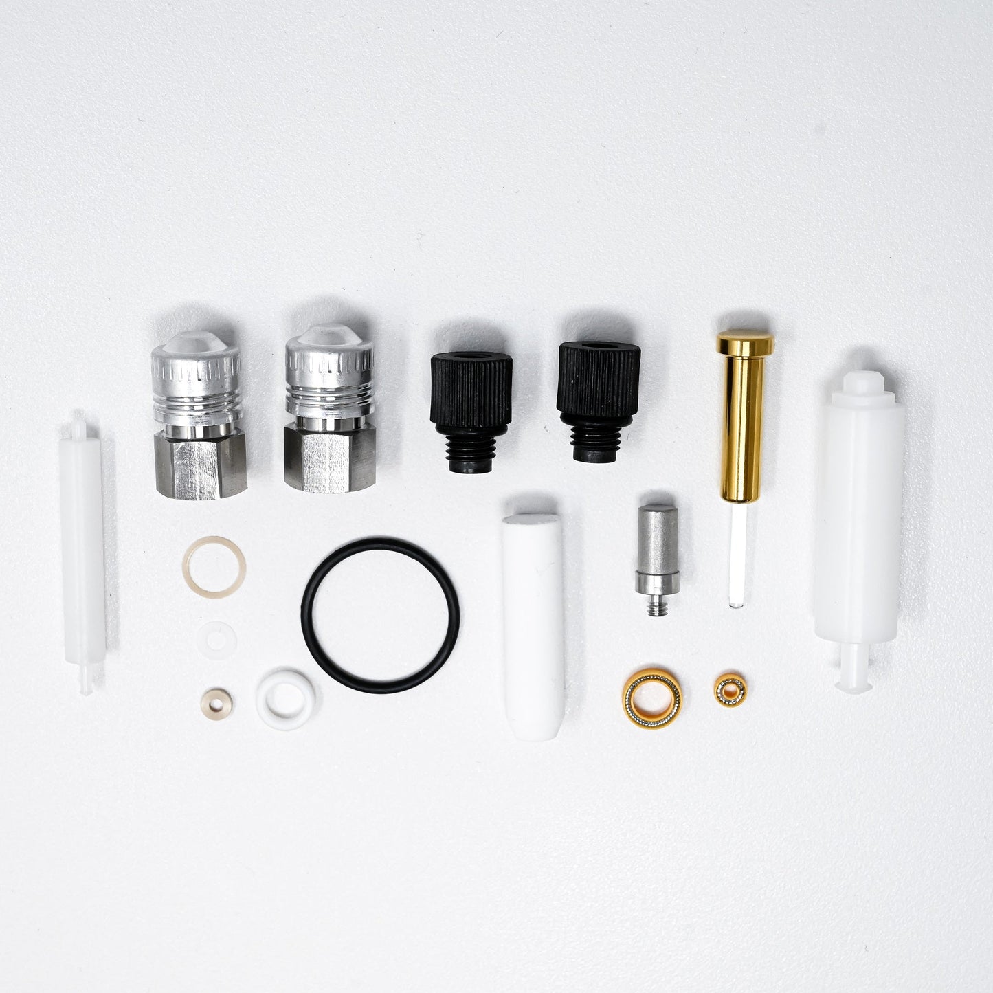 A collection of components for a pump, including various fittings and mechanical parts arranged neatly.