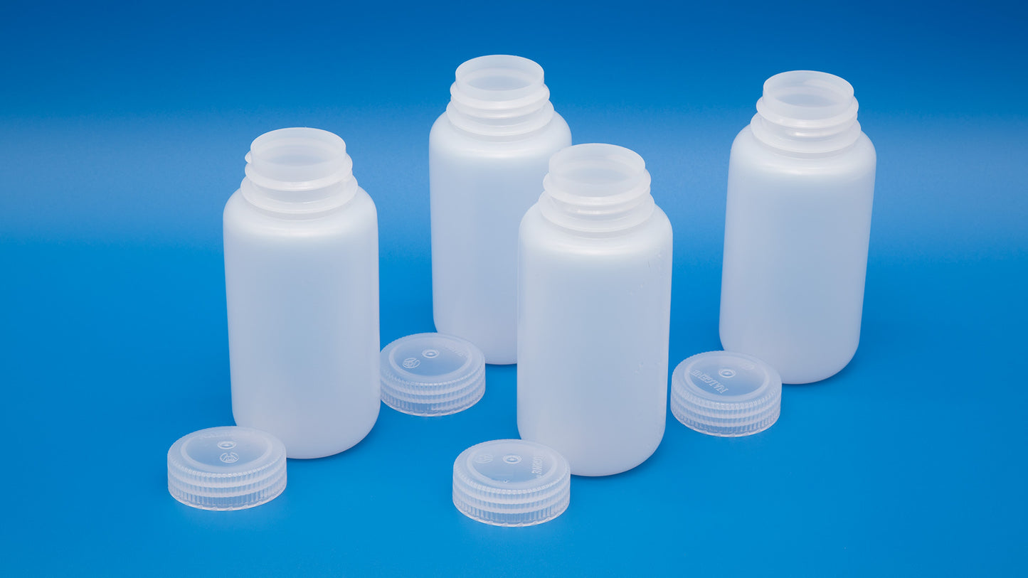 Four white plastic bottles with lids arranged neatly against a blue background, showcasing their clean design and color contrast.