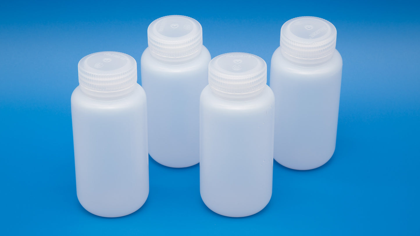 Four white plastic bottles with lids arranged neatly against a blue background, showcasing their clean design and color contrast.