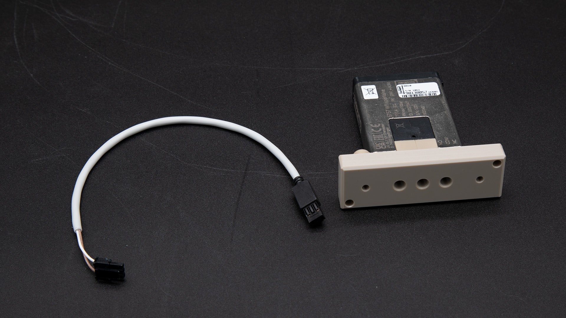 A small electronic device connected by a cable, showcasing its compact design and functionality.