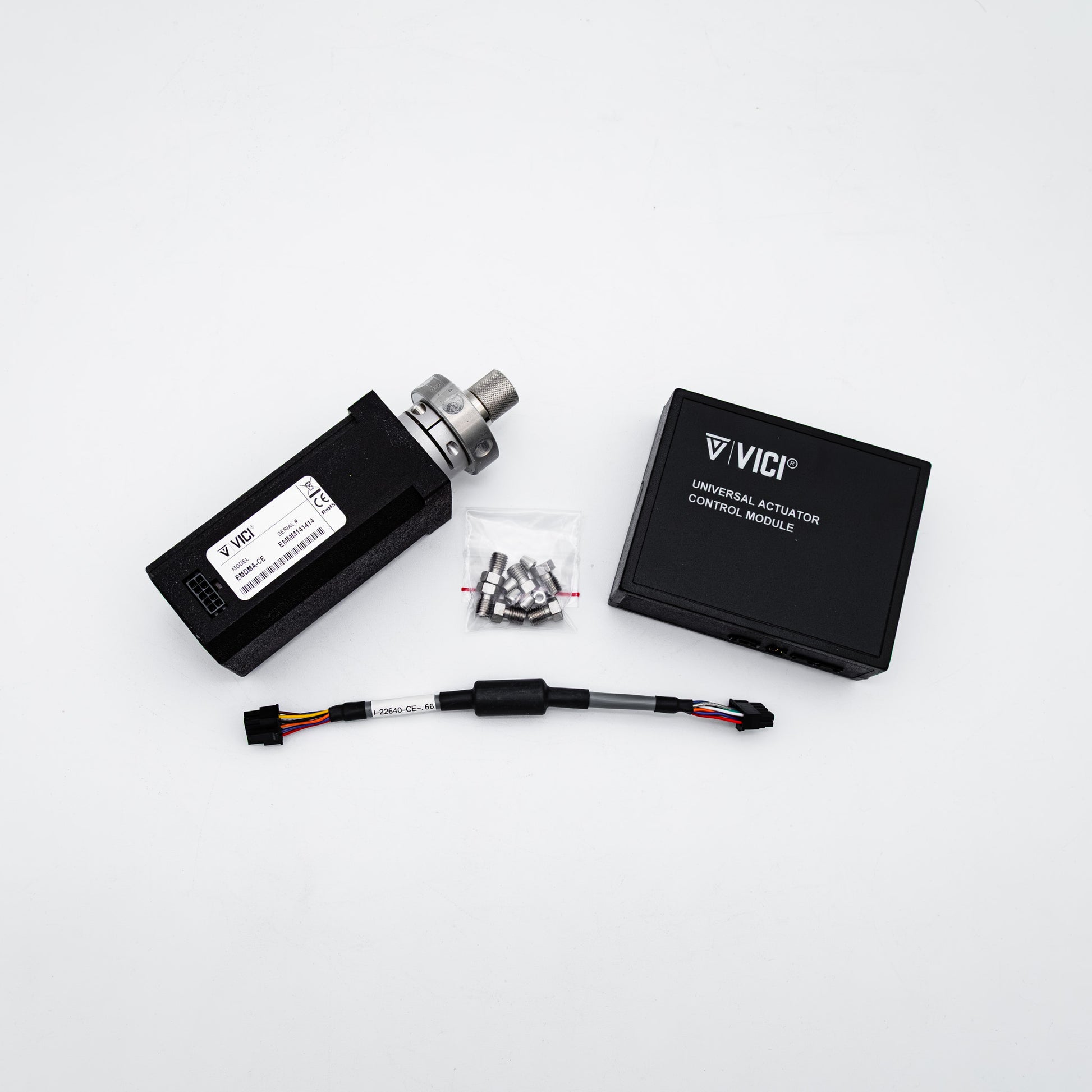 VICI Universal Actuator Control Module kit on a white background, including the black actuator body with metal fitting, black control module box, wiring harness, and small hardware bag.
