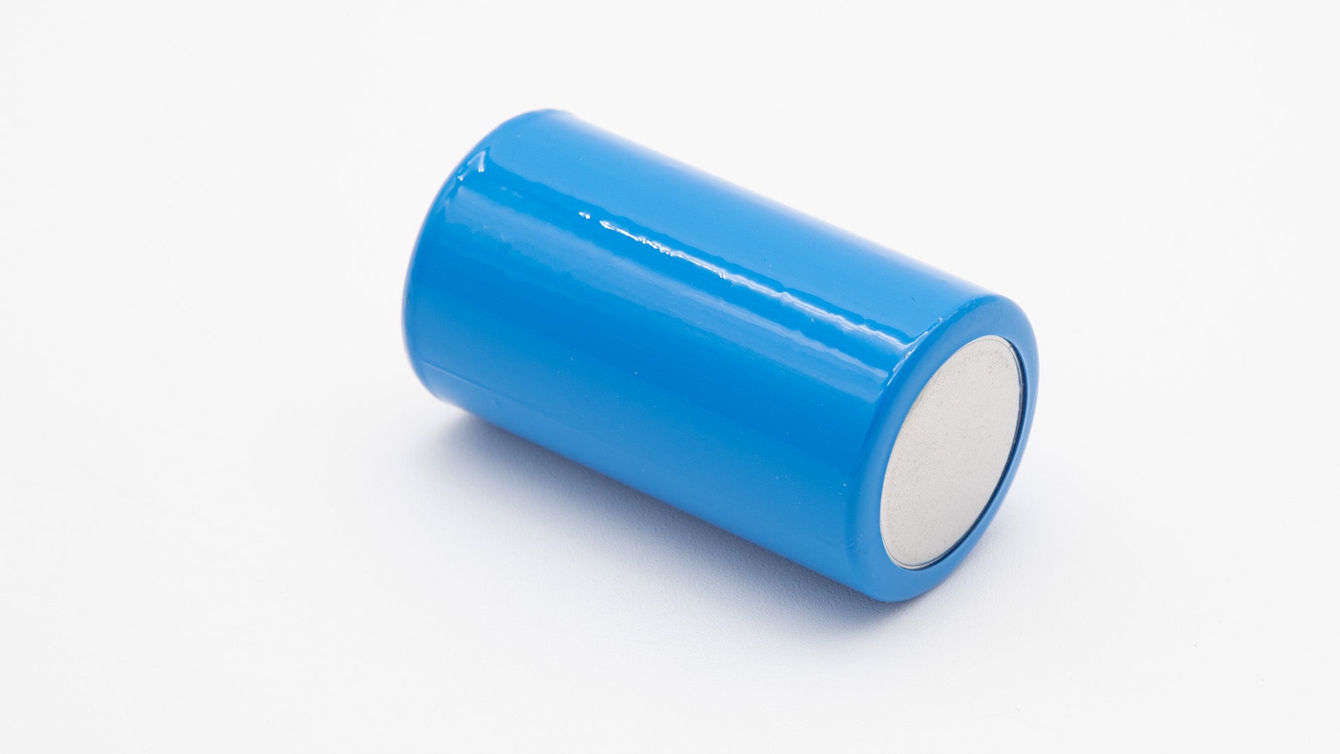 A blue cylindrical object with a white cap