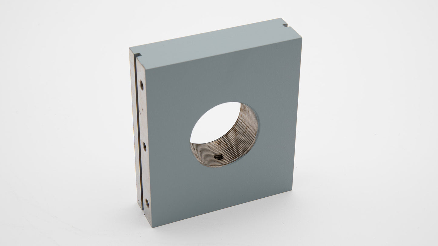 A grey rectangular object with a threaded hole