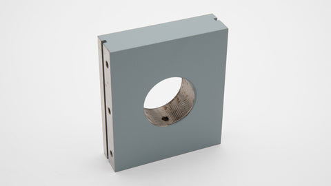 A grey rectangular object with a threaded hole