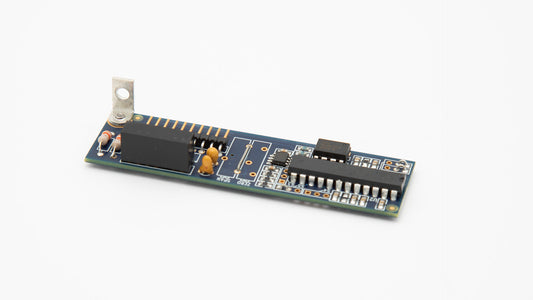 A compact electronic board featuring a small device, showcasing intricate circuitry and components.
