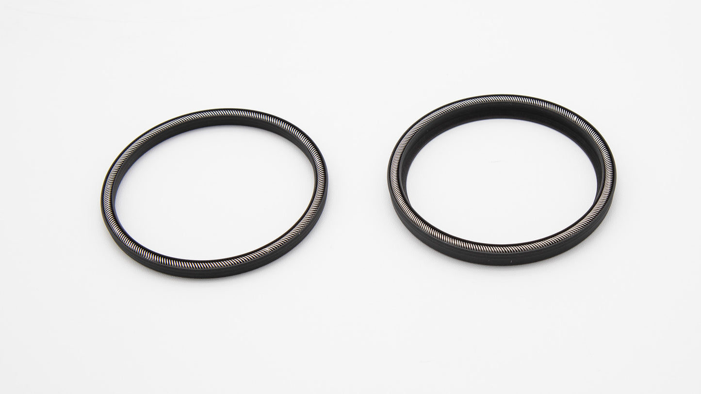 Two black circular seals with installed springs.