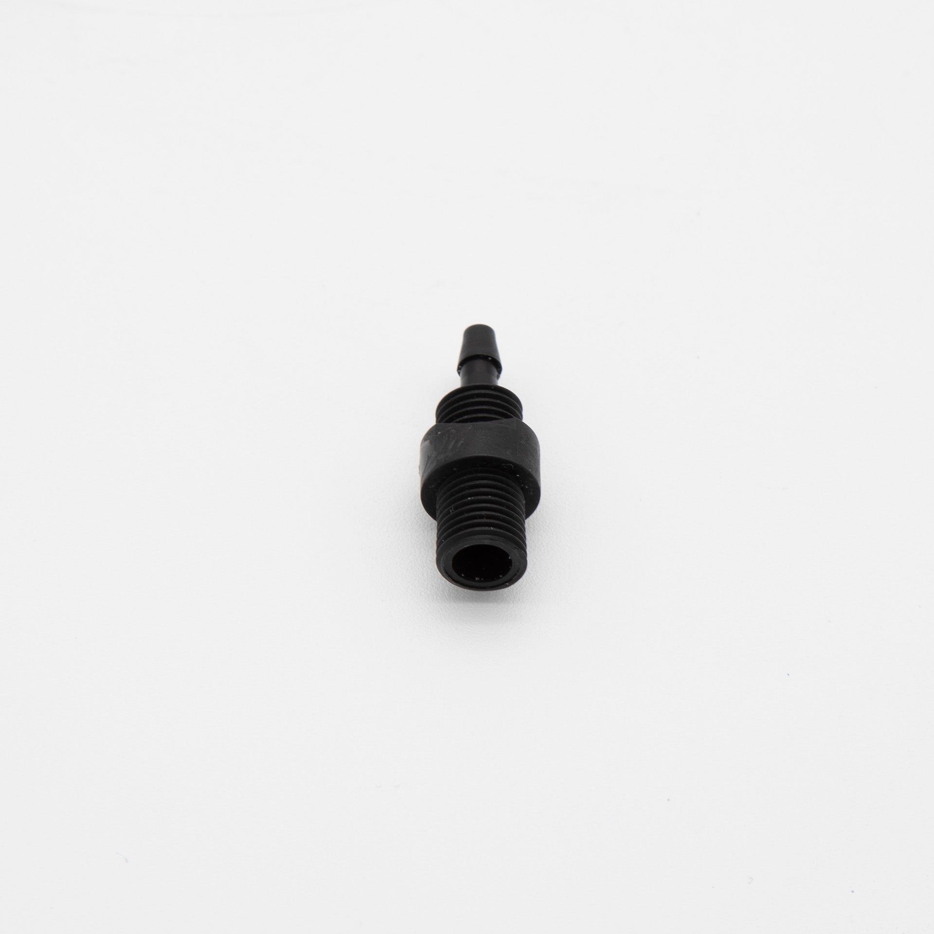 A black plastic threaded fitting positioned against a clean white background, showcasing its design and texture.