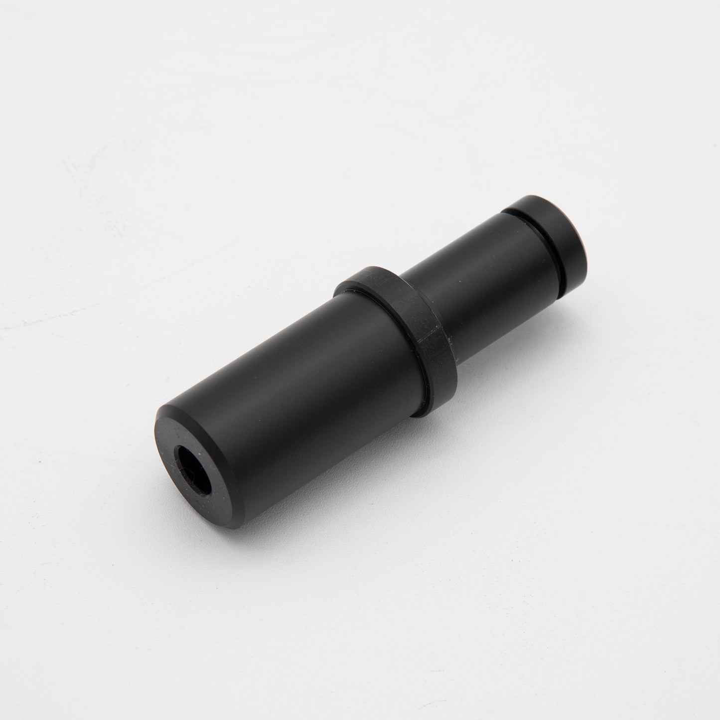 A black plastic pipe with a small hole, emphasizing its functional aspect and material composition.