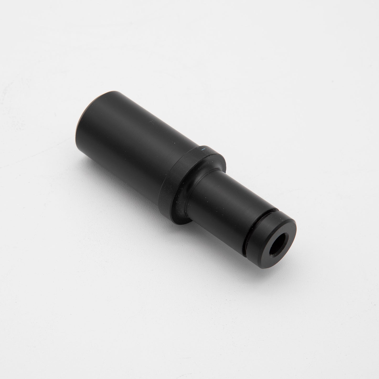 A black plastic pipe with a small hole, emphasizing its functional aspect and material composition.