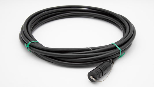 A black cable intertwined with a green cord, set against a clean white background.