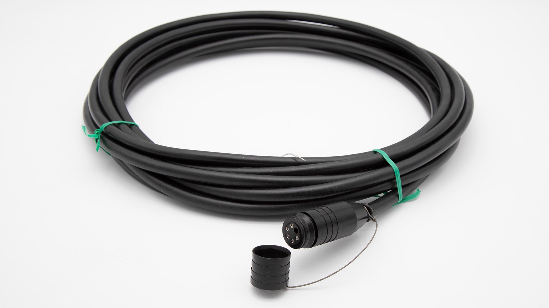 A black cable intertwined with a green cord, set against a clean white background.