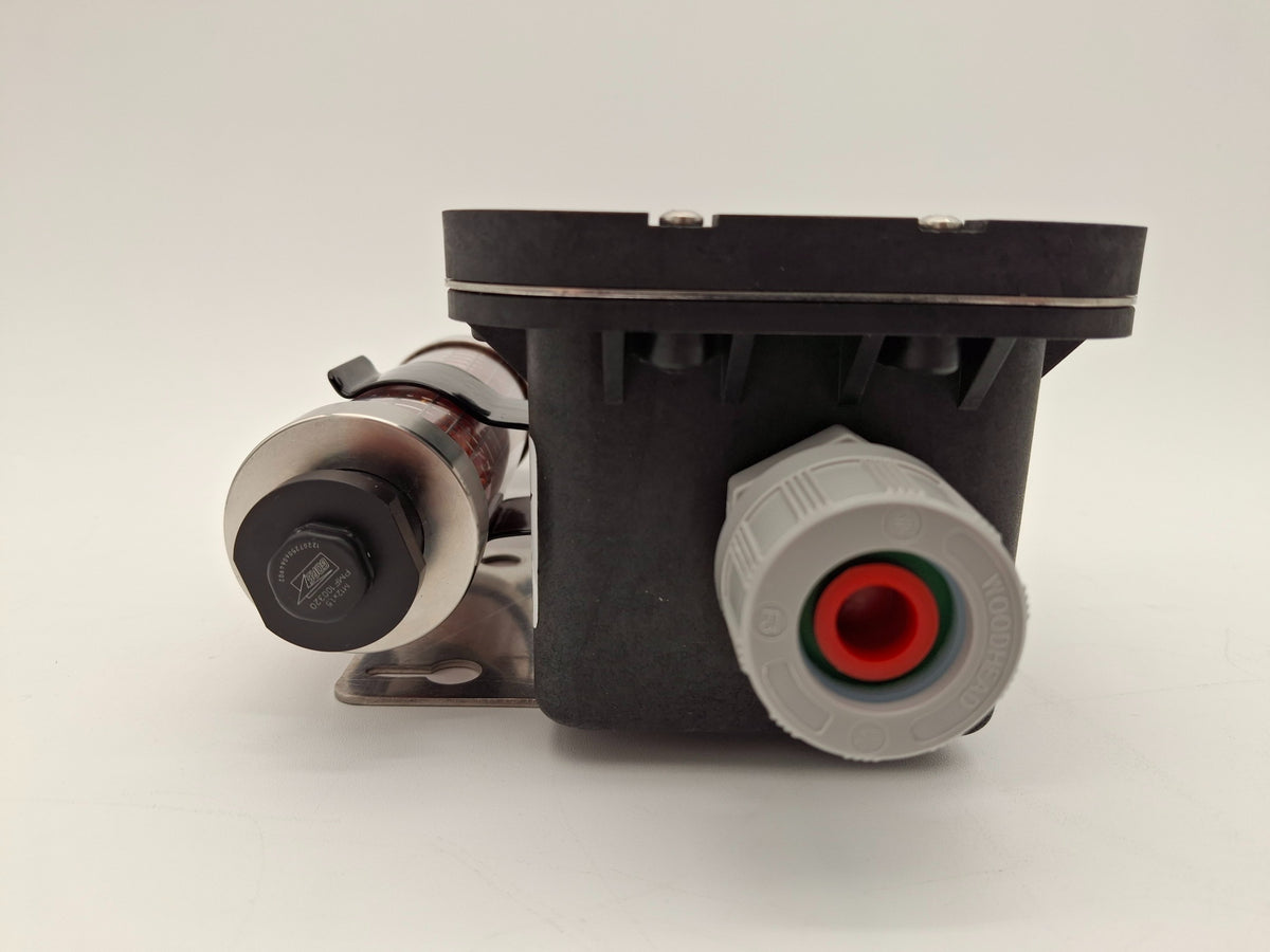 Close-up image featuring a black box and component with an orange object, emphasizing the contrast between materials and color.