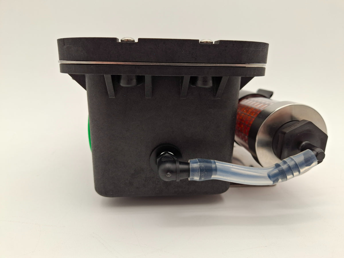 Close-up image featuring a black box and component with an orange object, emphasizing the contrast between materials and color.