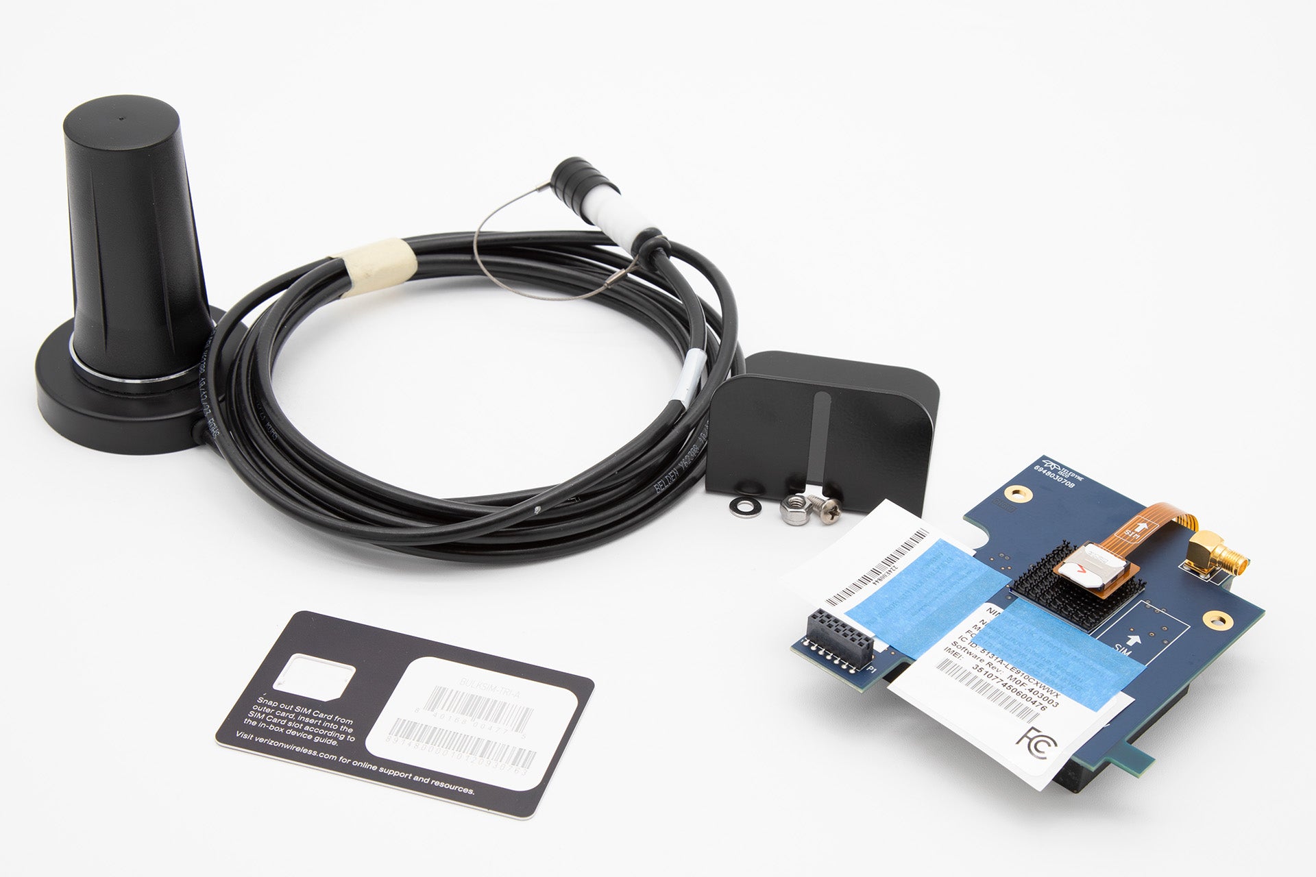 A wireless antenna alongside a SIM card and other related accessories, presented on a simple background.