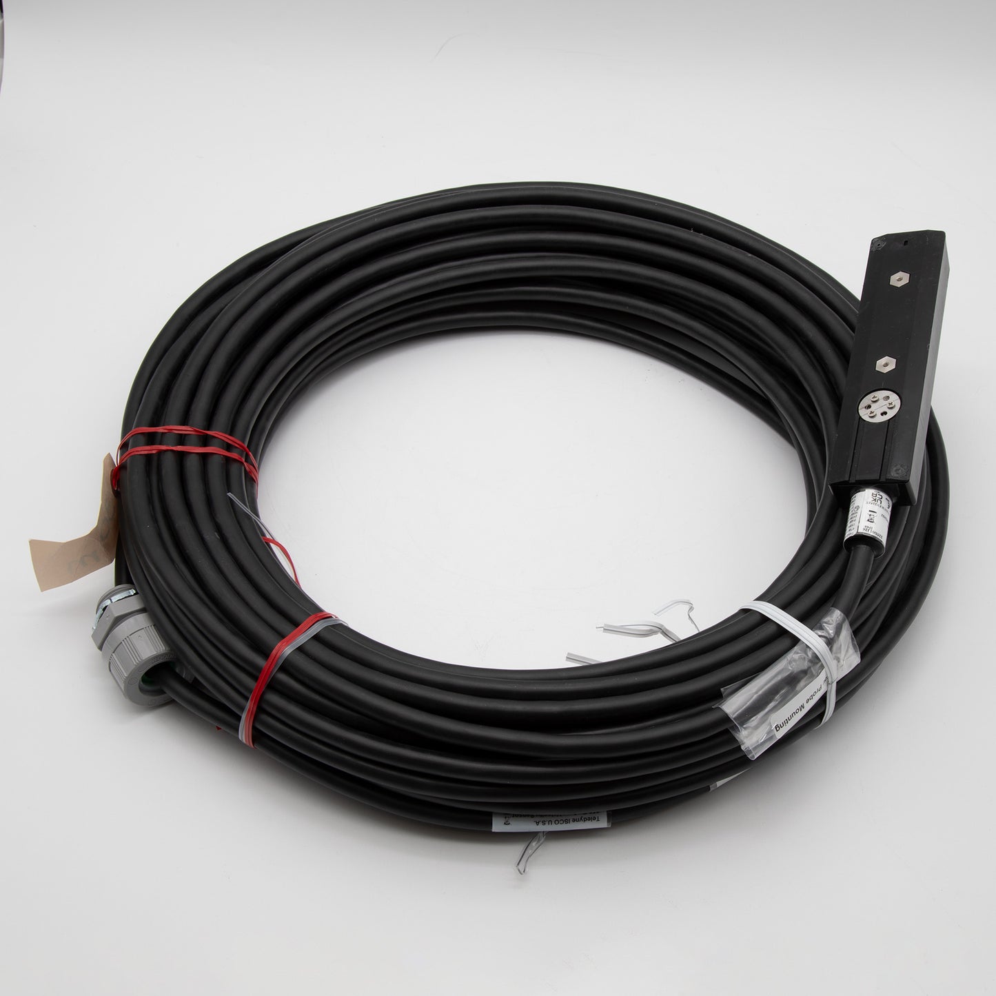 A black cable with a rectangular shaped sensor attached, positioned on a plain background.