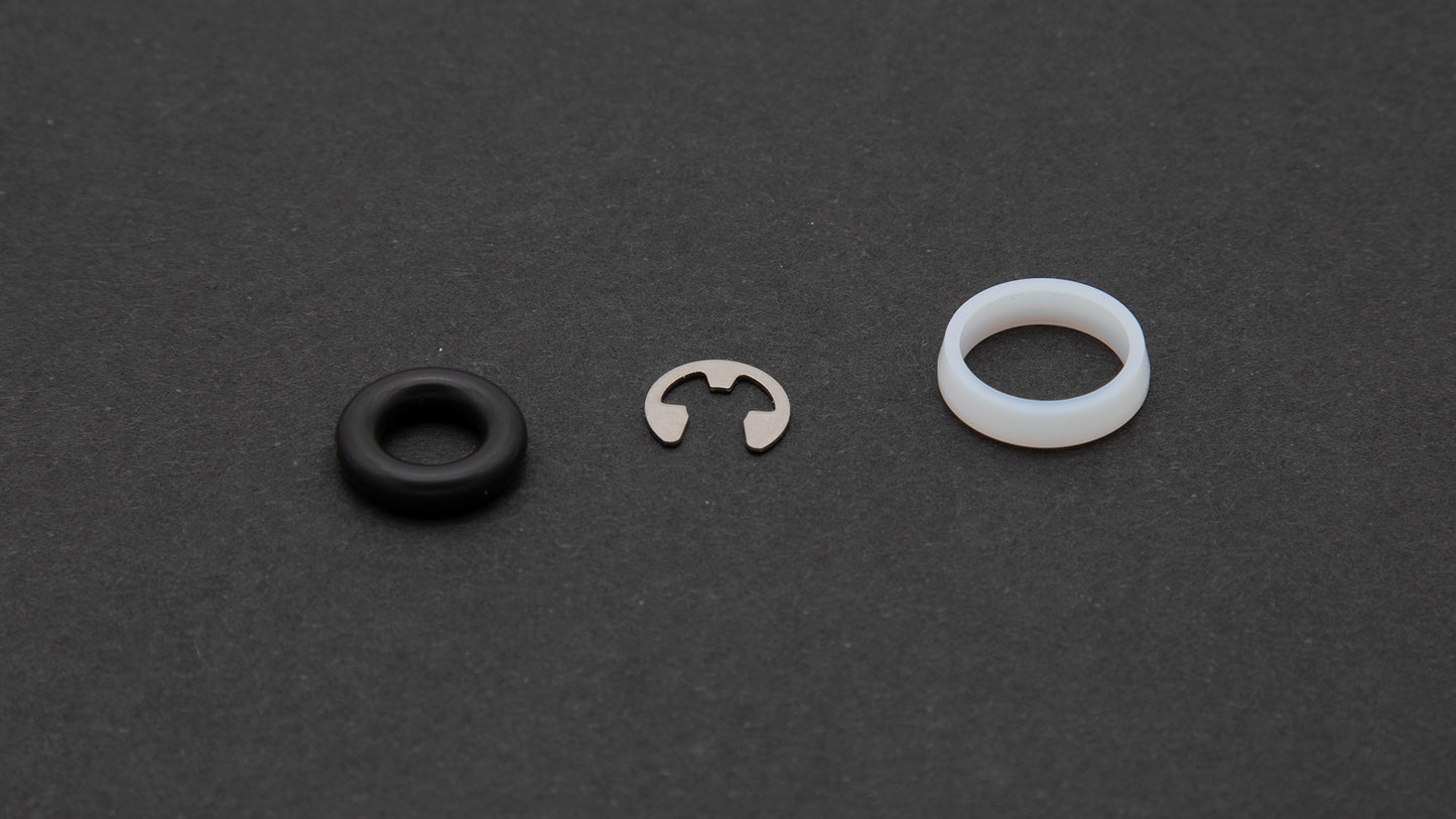 A black ring alongside a white ring, showcasing a stainless steel retaining ring.