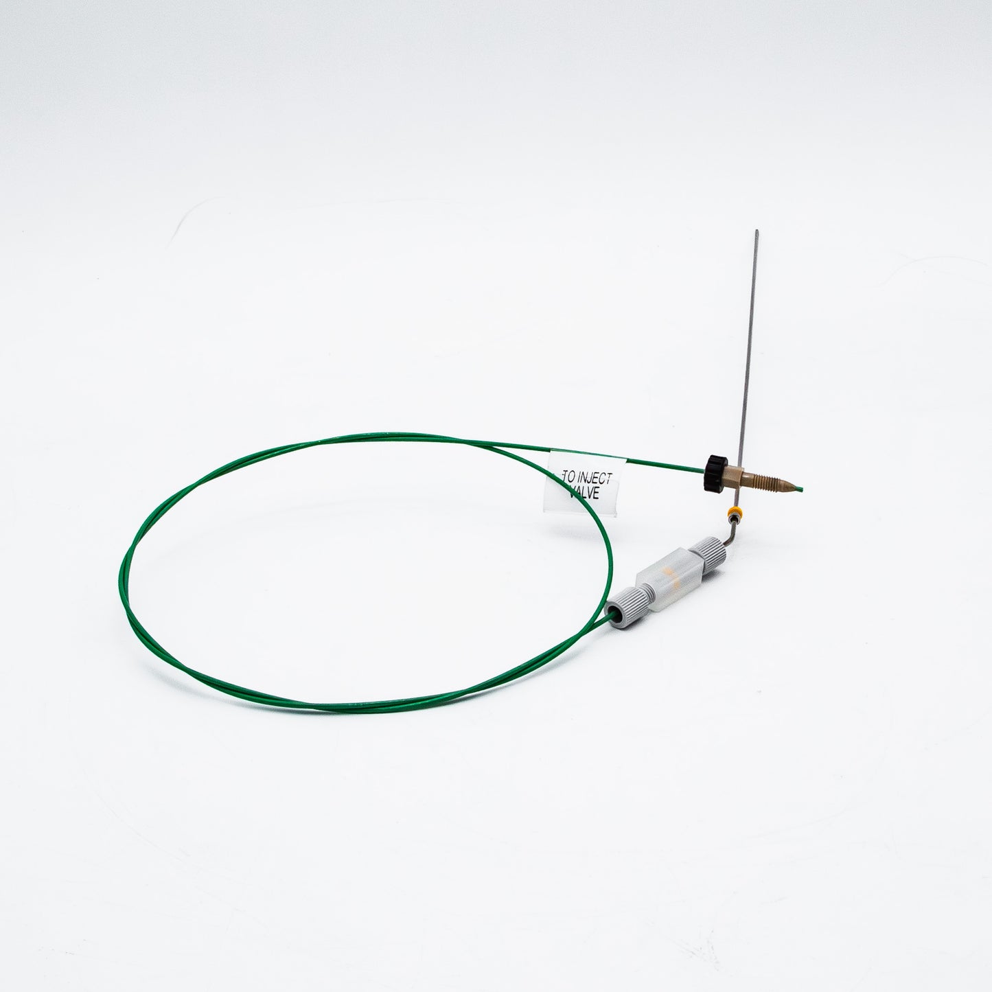 Device with green cable and needle on a white background