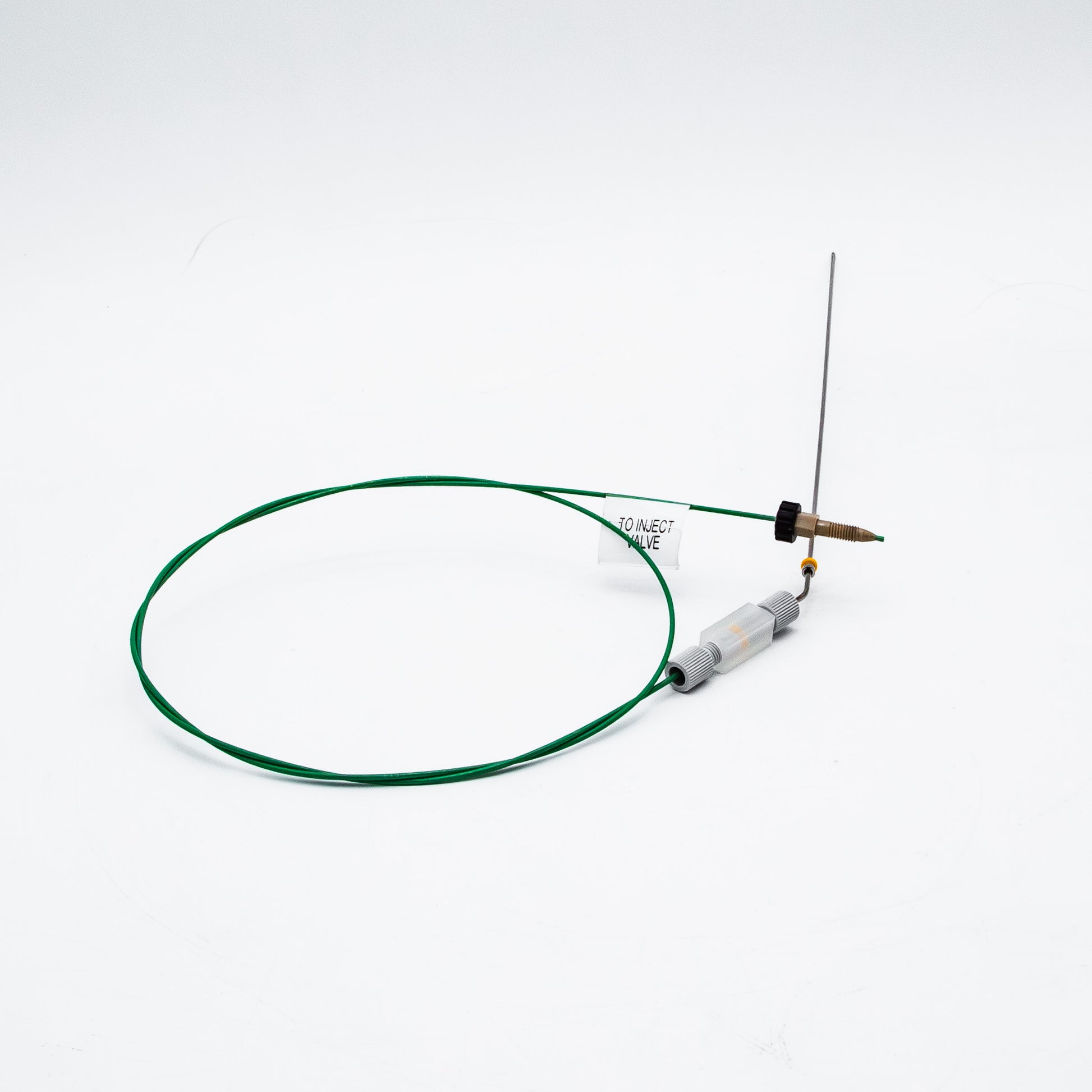 Device with green cable and needle on a white background