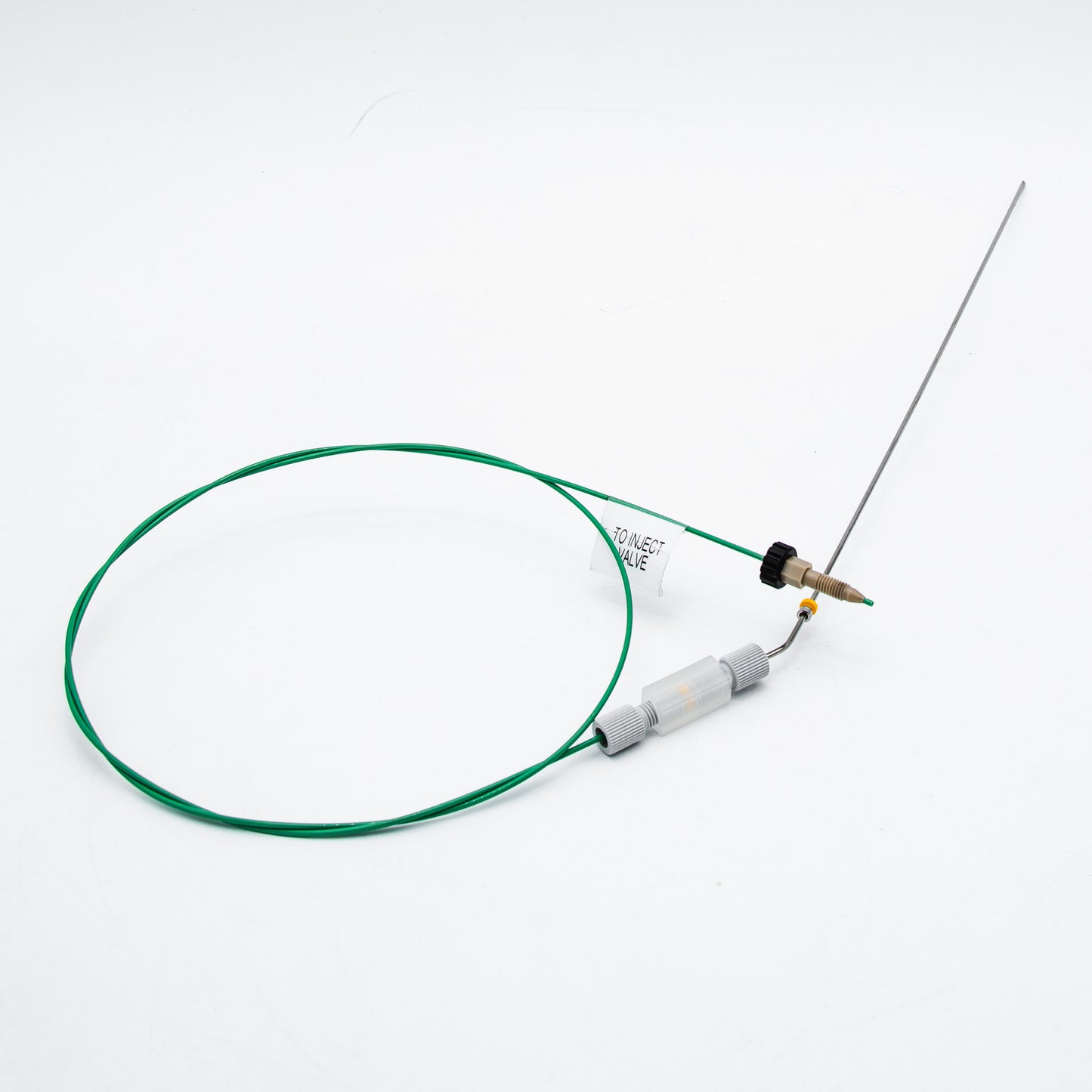 Device with green cable and needle on a white background