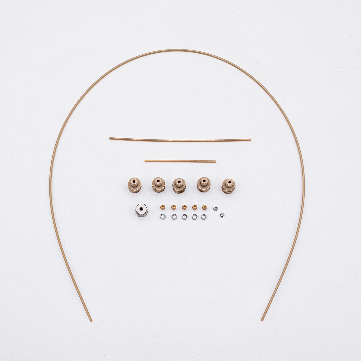 A set of tan-colored nuts and matching metal fittings arranged on a plain white background, with three varied sizes of tubing.