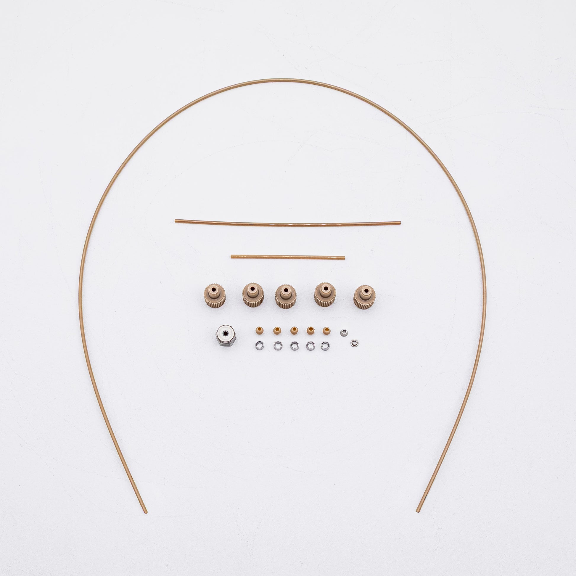 A set of tan-colored nuts and matching metal fittings arranged on a plain white background, with three varied sizes of tubing.