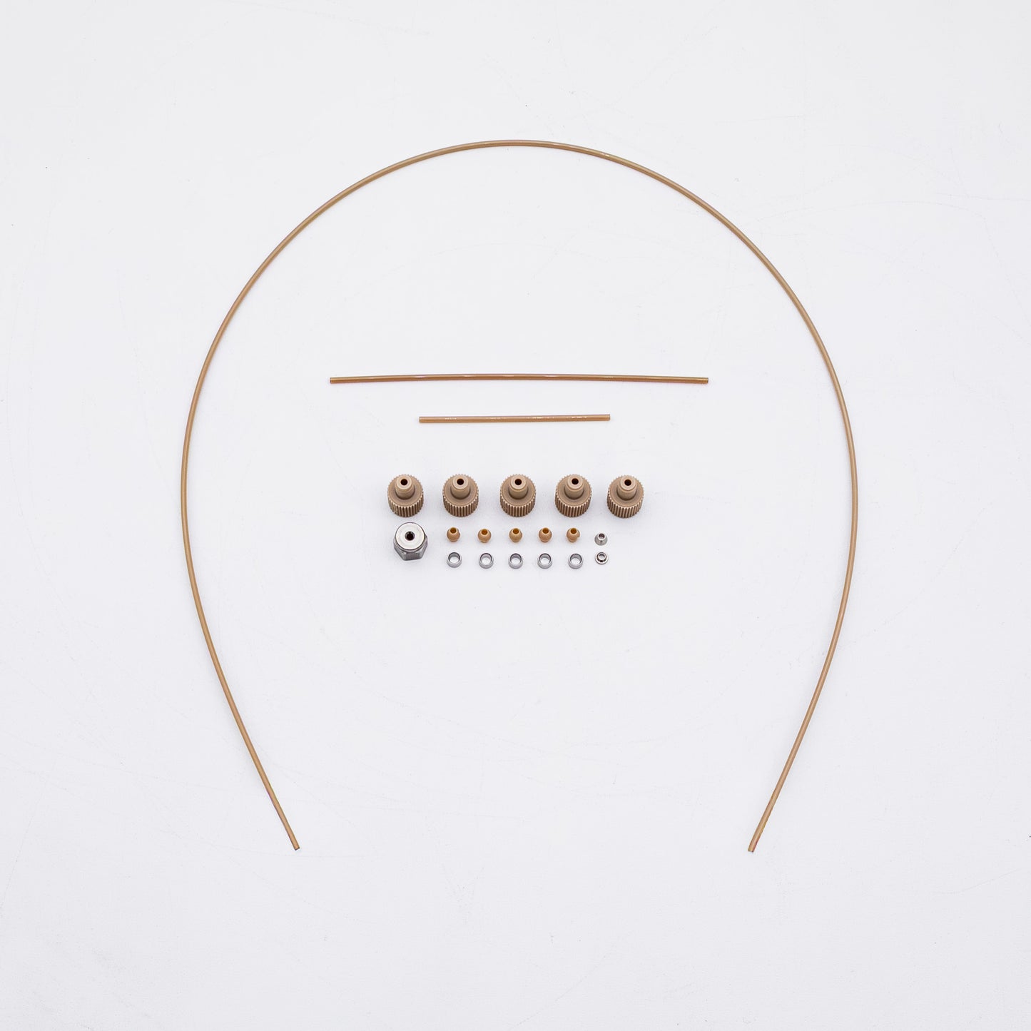 A set of tan-colored nuts and matching metal fittings arranged on a plain white background, with three varied sizes of tubing.