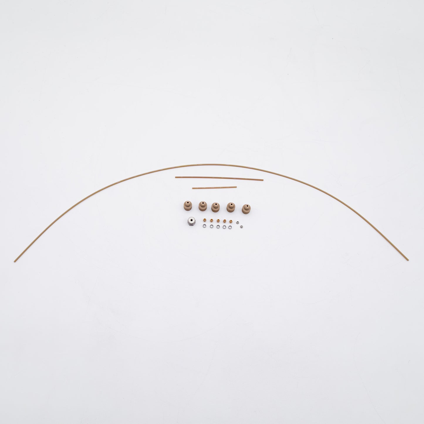 A set of tan-colored nuts and matching metal fittings arranged on a plain white background, with three varied sizes of tubing.