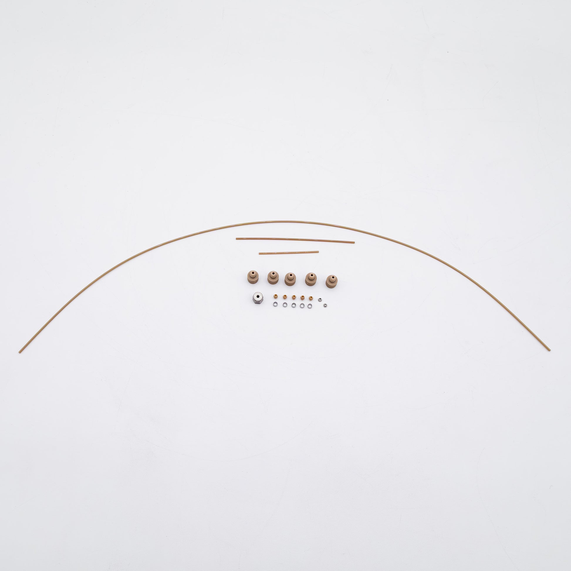 A set of tan-colored nuts and matching metal fittings arranged on a plain white background, with three varied sizes of tubing.