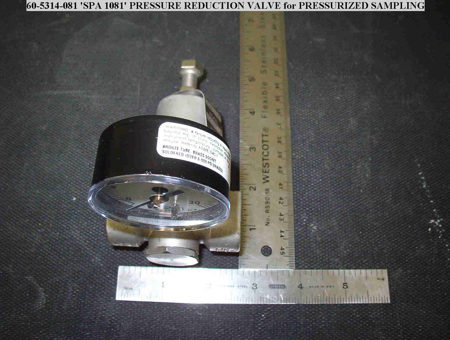 A pressure gauge positioned on a table, featuring a clear dial with measurement markings.