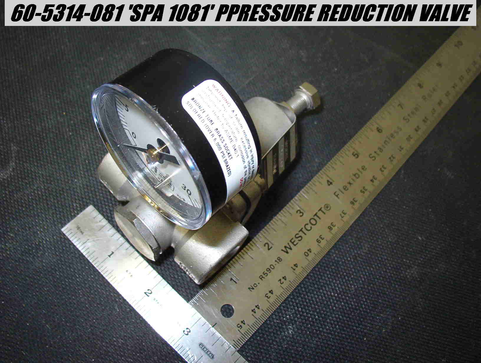 A pressure gauge positioned on a table, featuring a clear dial with measurement markings.
